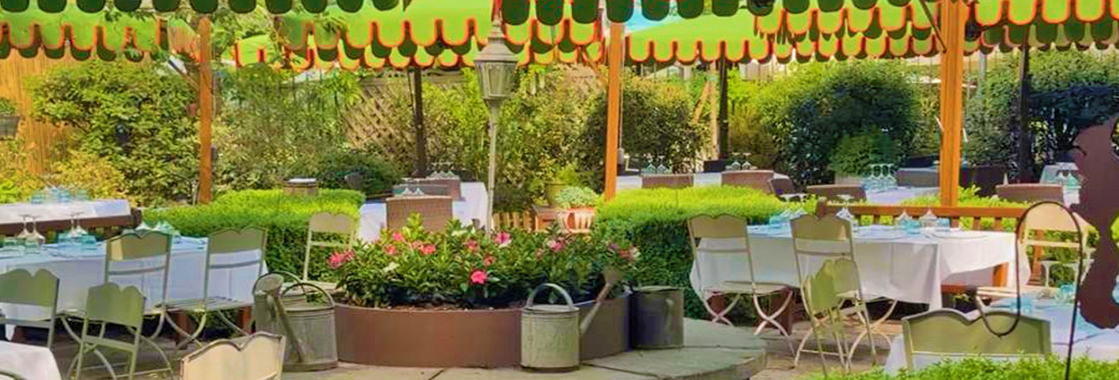 Giardino del Ristorante Al Fresco Milano, tavoli apparecchiati sotto una pergola decorata e circondati da piante